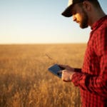 Man in a field with an ipad