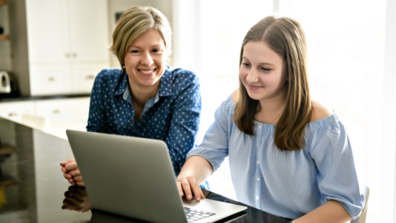 Mom sitting with daughter looking at computer