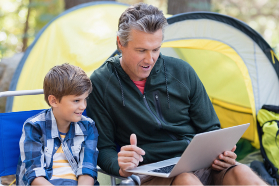 dad and son on the internet at a campground