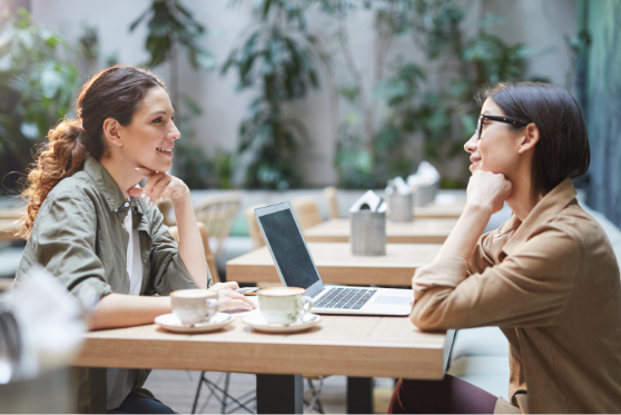 Two women at a cafe with laptop computer