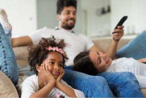 Family of three watching tv together